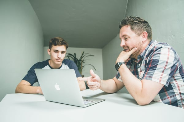 Two men looking at laptop