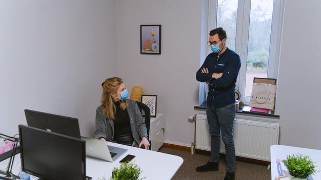 woman-and-man-wearing-masks-in-office